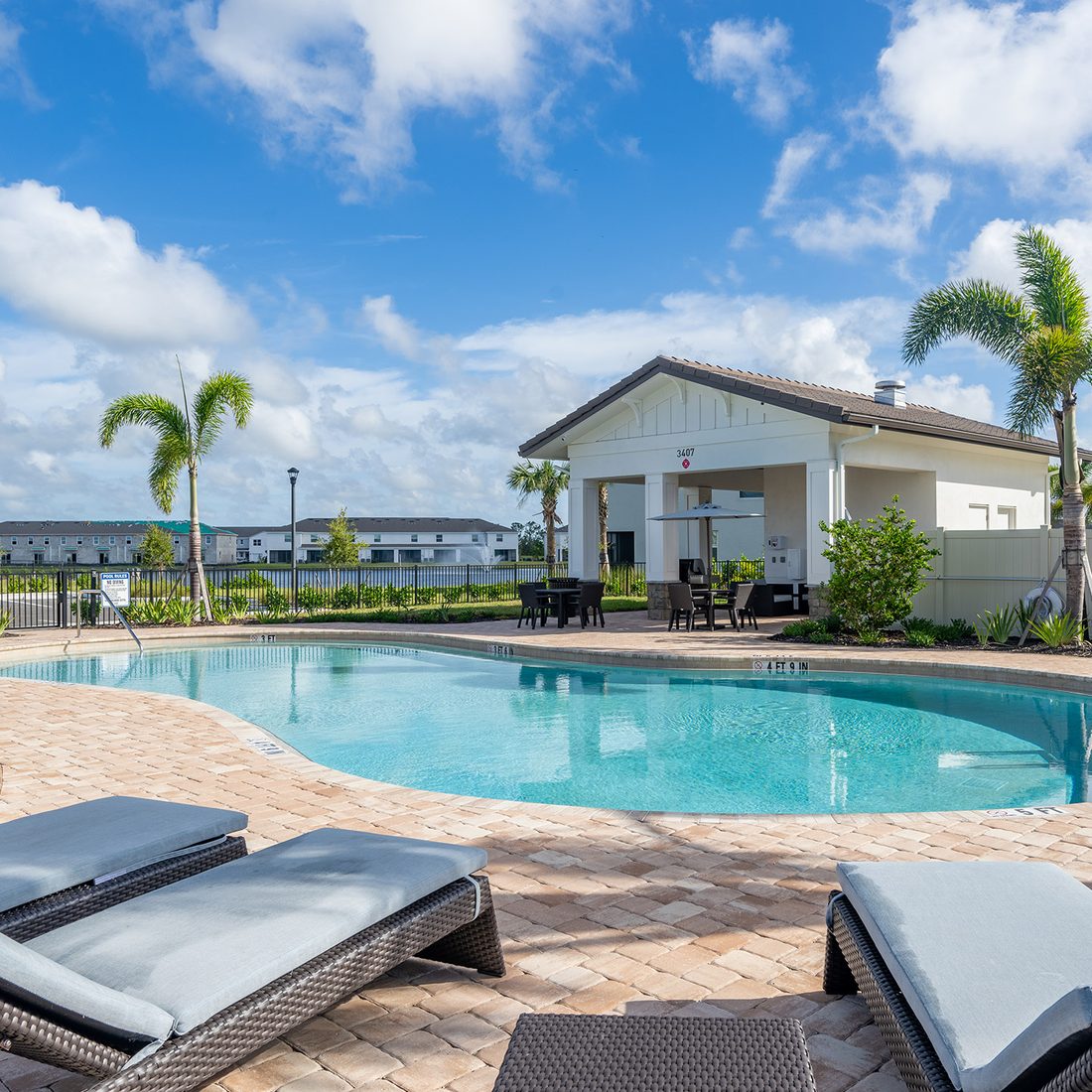 Resort pool with lounge chairs and a covered pavilion beside a lake at Cabana Corner